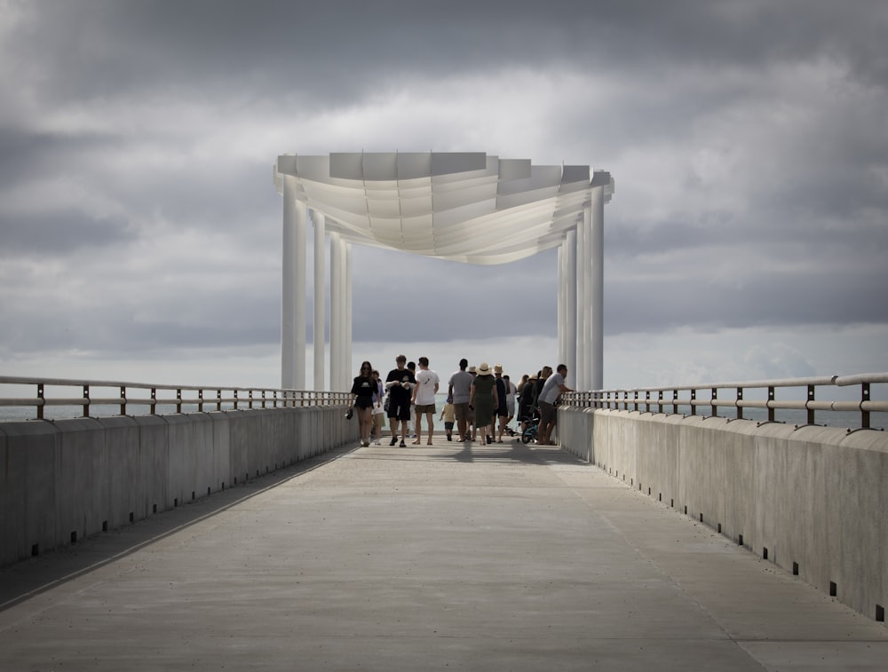 a group of people walking across a bridge