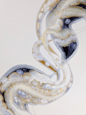 An abstract design of swirling patterns resembling organic or cellular structures, featuring a mix of fluid shapes and textures in a harmonious arrangement.
