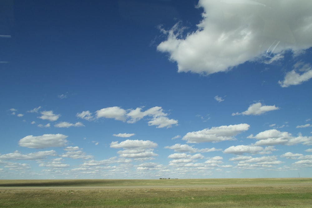 a large open field with a few clouds in the sky