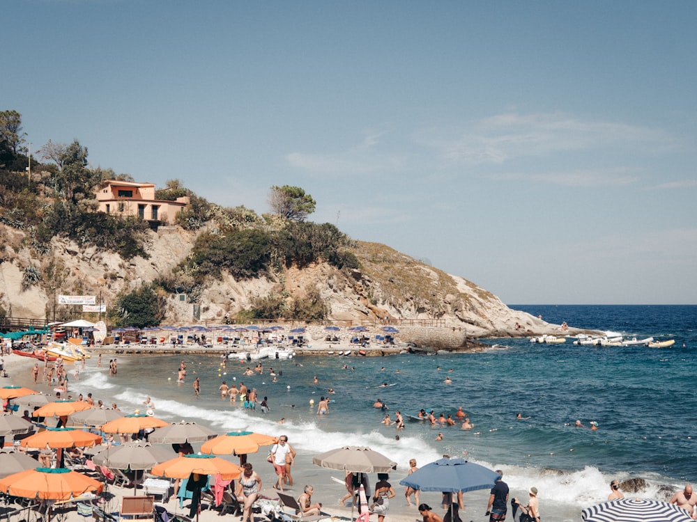 a crowded beach with lots of people and umbrellas