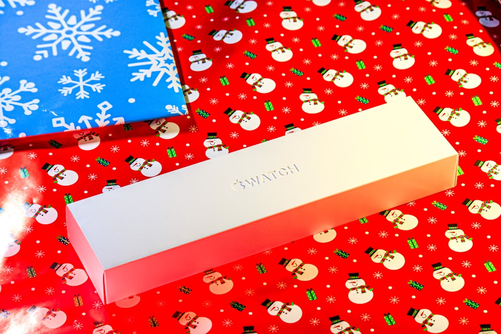 a white box sitting on top of a red wrapping paper