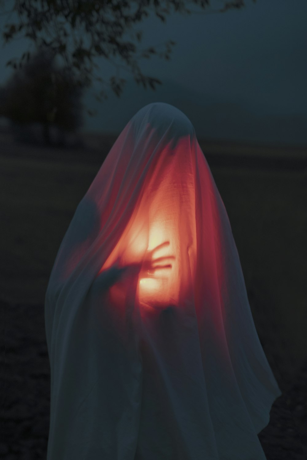 a person in a white cloth with a red light in their hand
