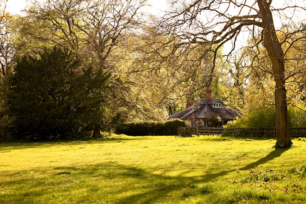 a house sitting in the middle of a lush green field