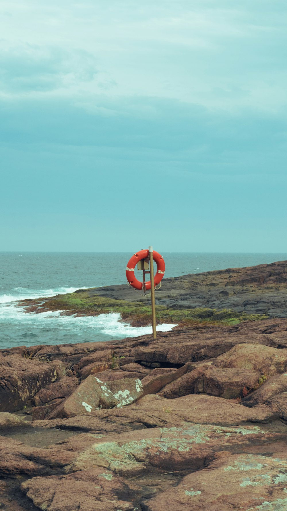 a life preserver on a rocky shore by the ocean