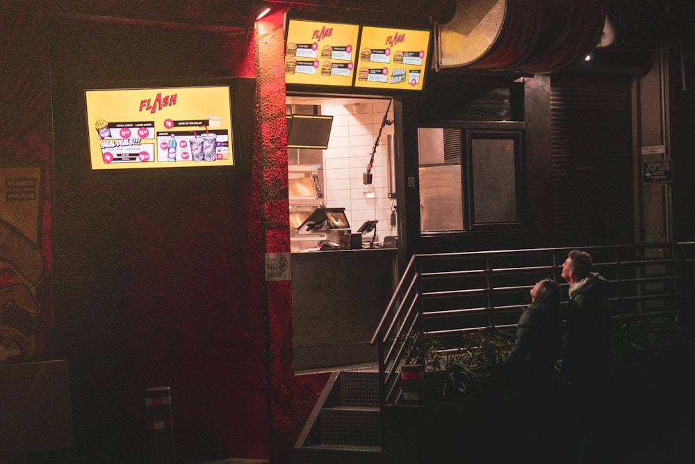 a man sitting on a bench in front of a restaurant