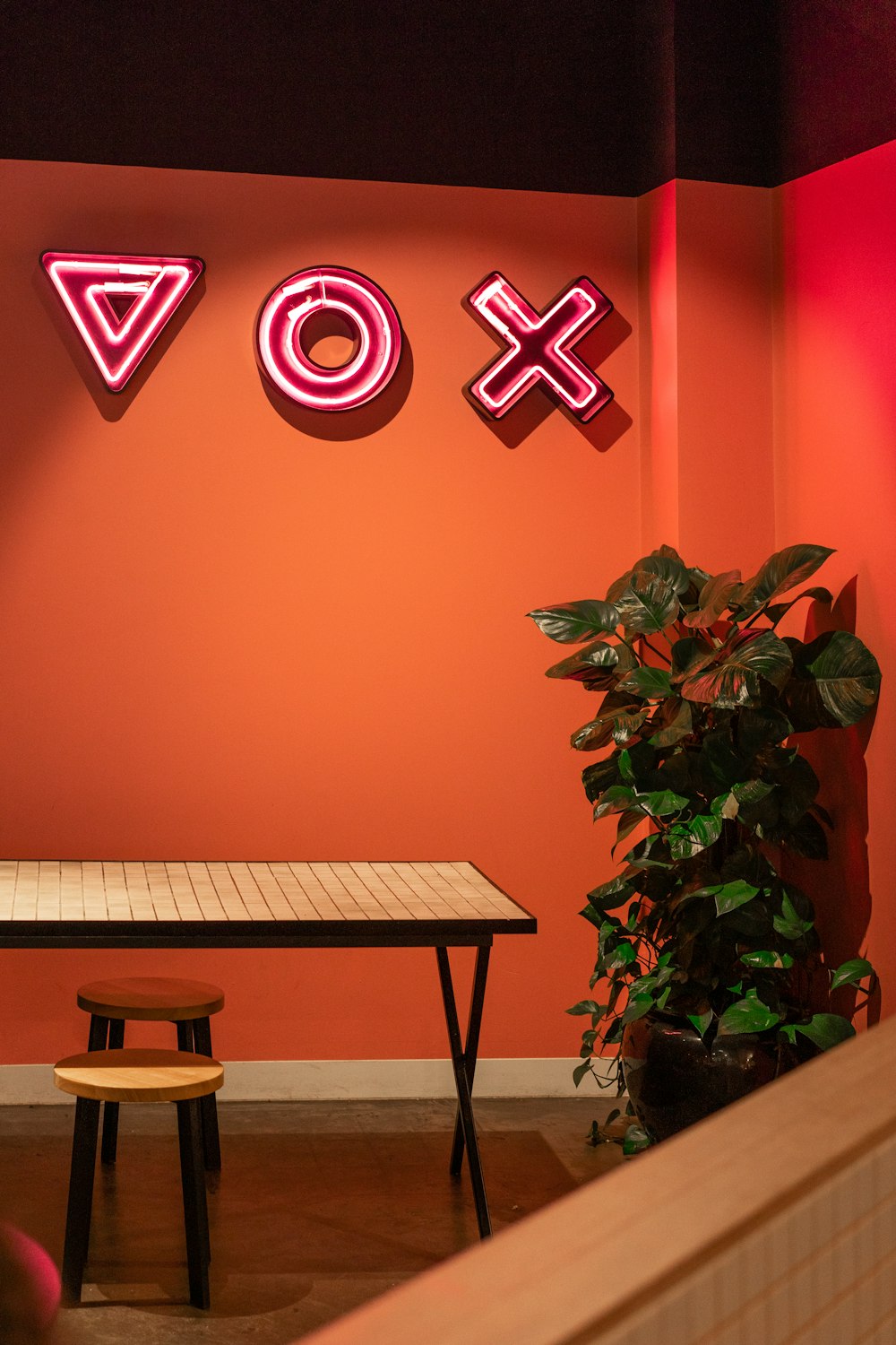 a room with a table and a neon sign on the wall