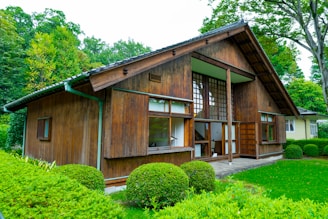 a small wooden house with a green lawn