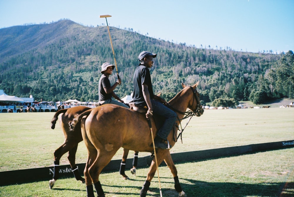 a couple of people riding on the backs of horses