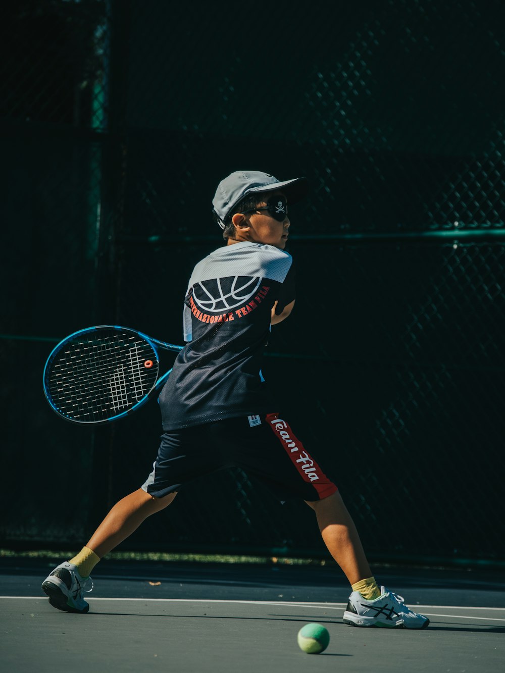 a young man holding a tennis racquet on a tennis court