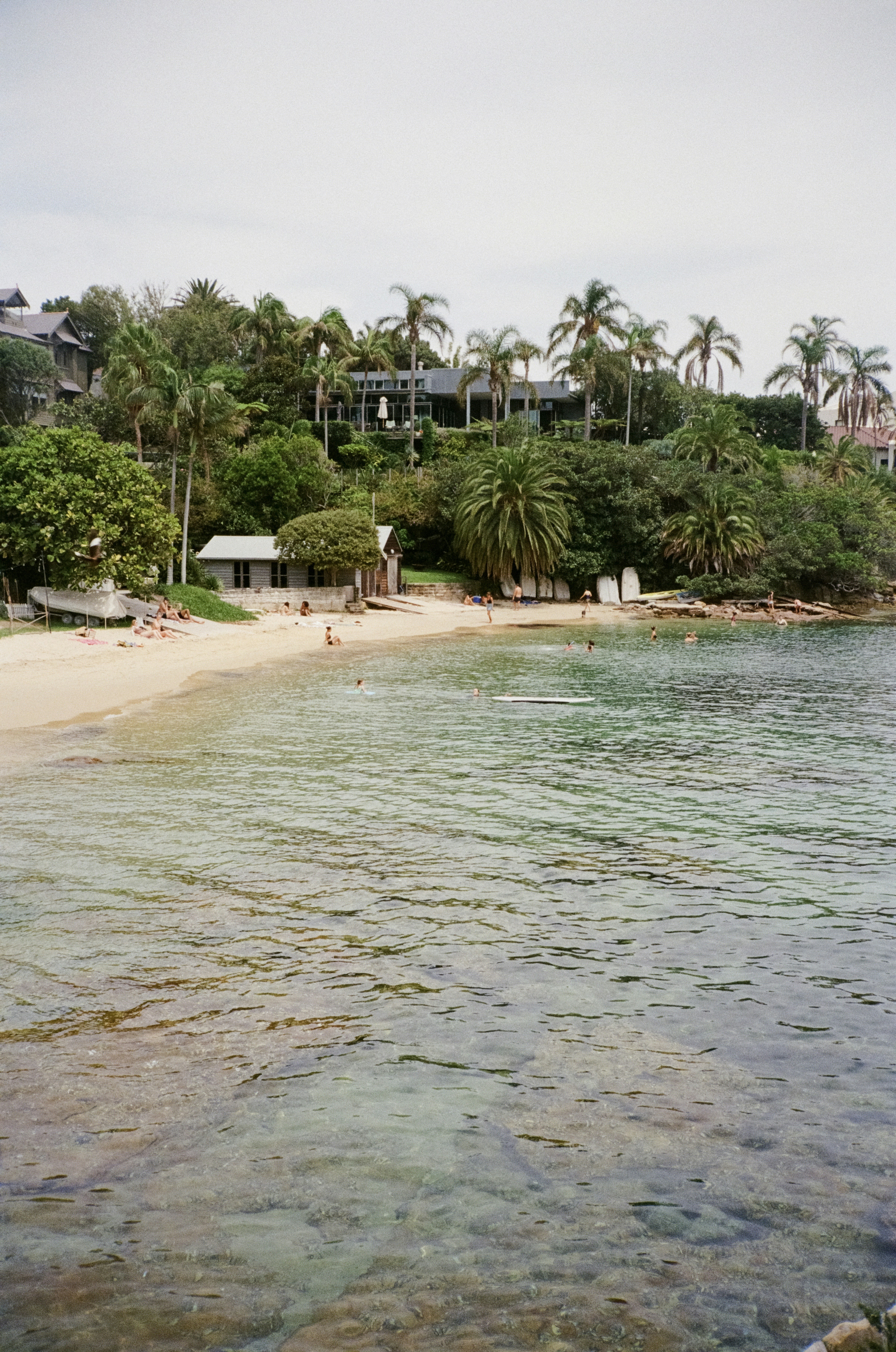 a view of a beach with people swimming in the water