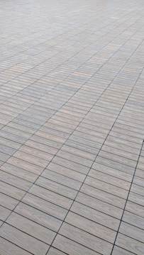 Natural wood-look porcelain tiles arranged seamlessly across a spacious room.