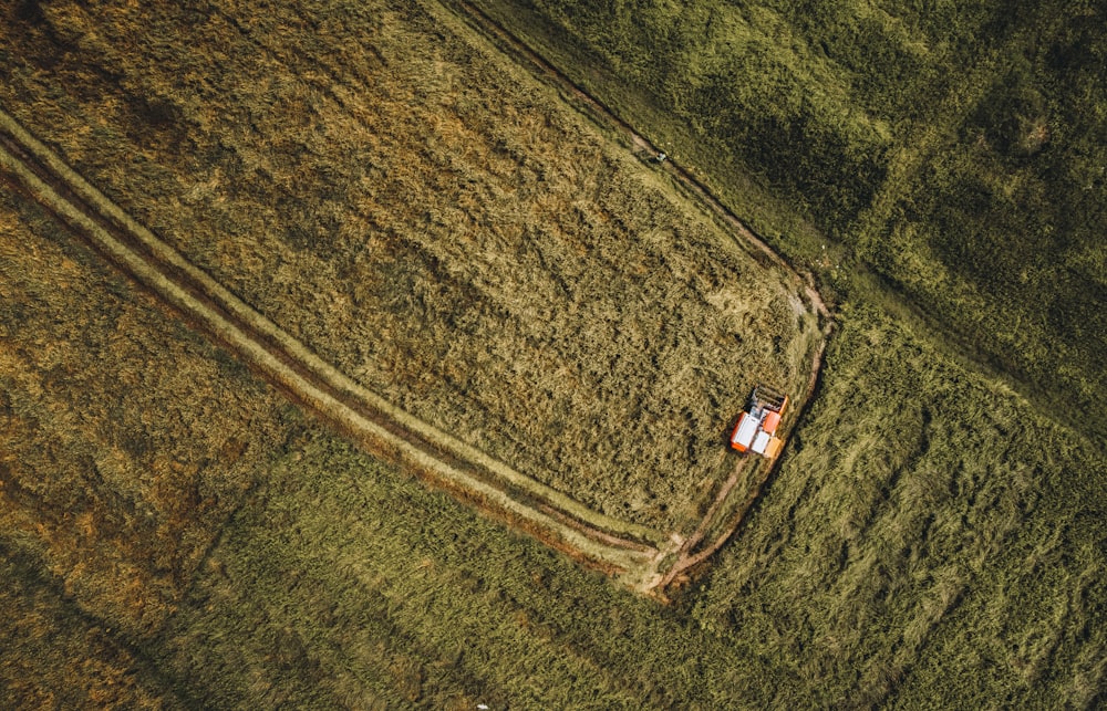 an aerial view of a field with a house in the middle of it