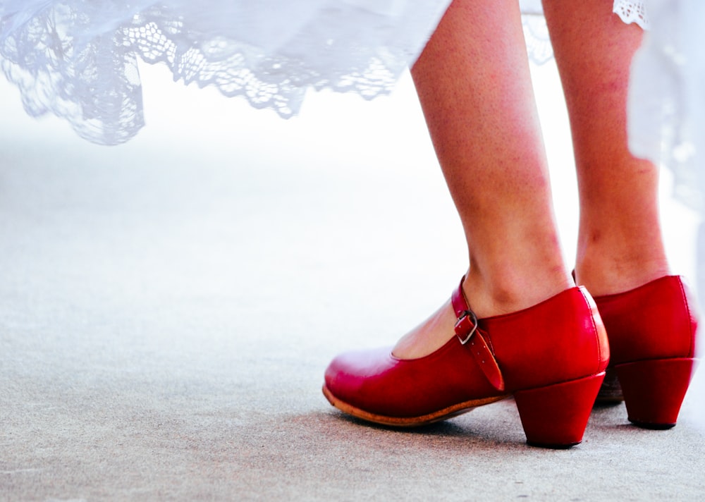 a close up of a person wearing red shoes