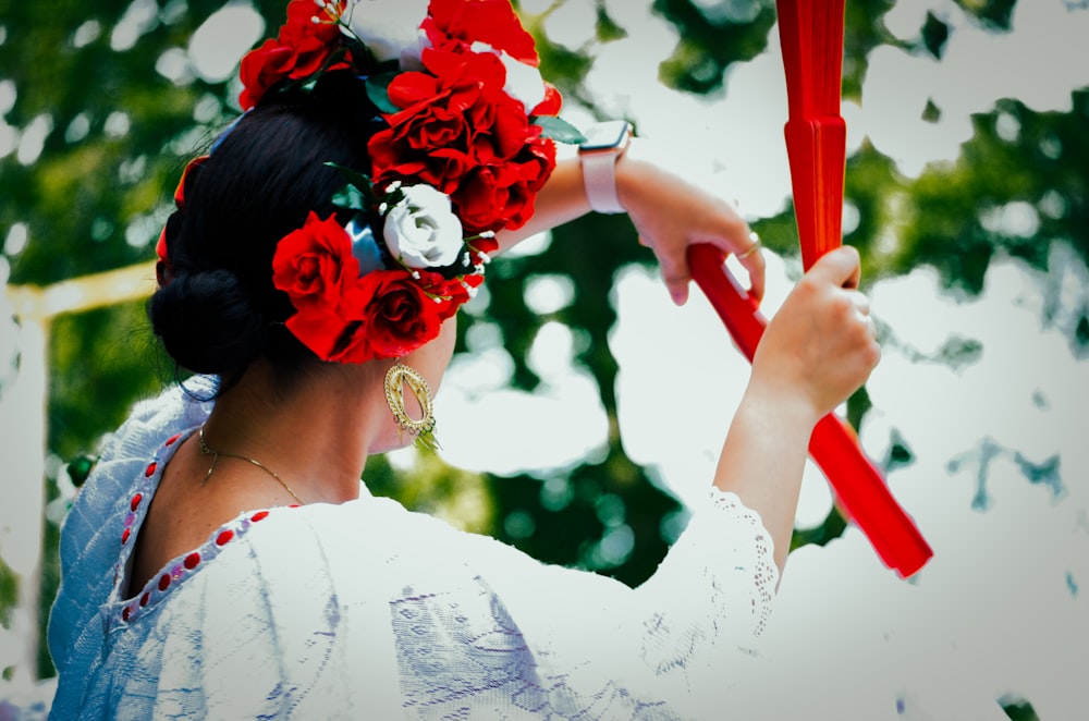 a woman with a flower in her hair holding a red umbrella