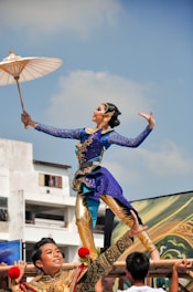 a woman in a blue and gold costume holding an umbrella