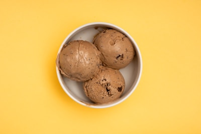 Artisan chocolate chunks melting into a bowl of freshly blended cold fruit ice cream.