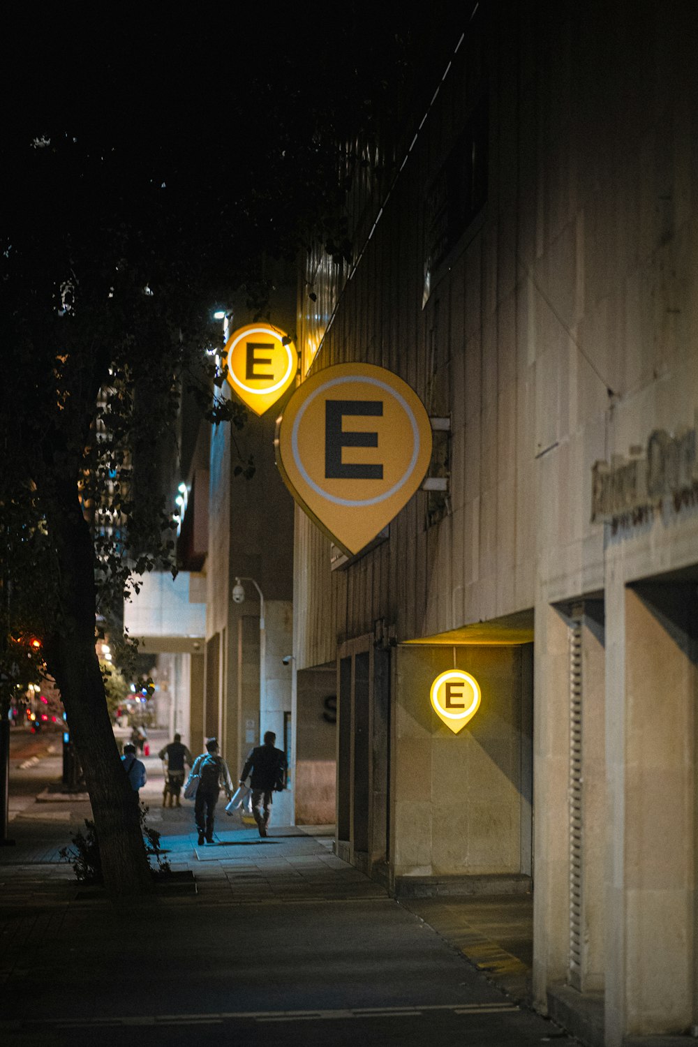 a couple of people walking down a street at night