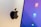 A close-up view of a computer screen displaying app icons on a blue background, next to a metallic surface with an Apple logo.