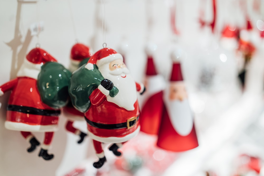 Eine Gruppe von Weihnachtsmann-Ornamenten, die an einer Wand hängen