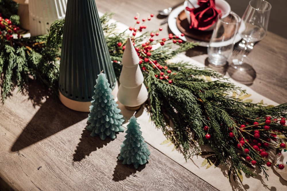a wooden table topped with christmas trees and candles