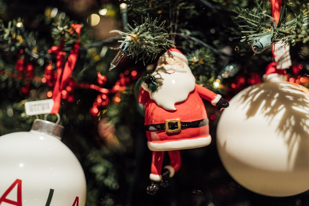 a santa clause ornament hanging from a christmas tree