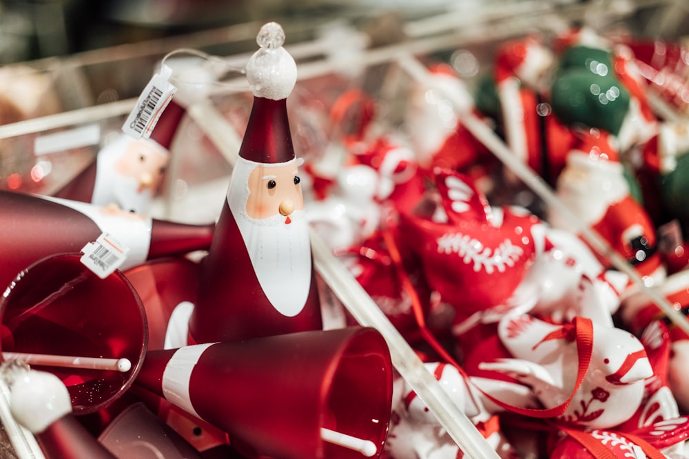 a santa clause figurine sitting on top of a pile of red and white