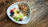 A vibrant bowl of fresh fruit custard topped with colorful seasonal fruits and a sprinkle of nuts.