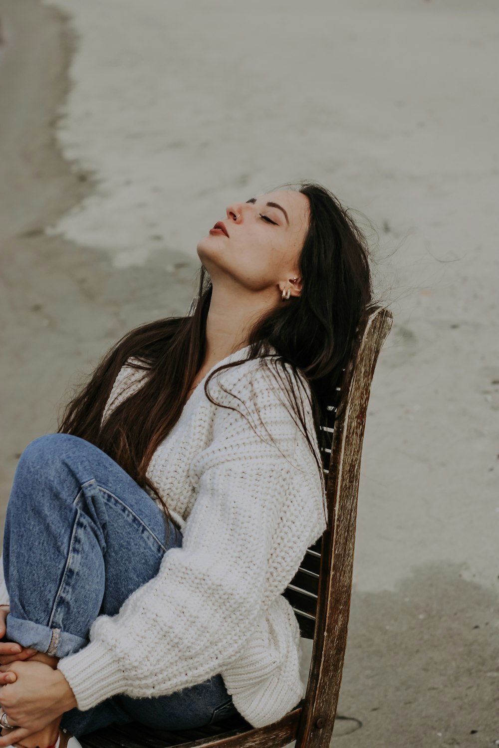 a woman sitting on a chair with her eyes closed