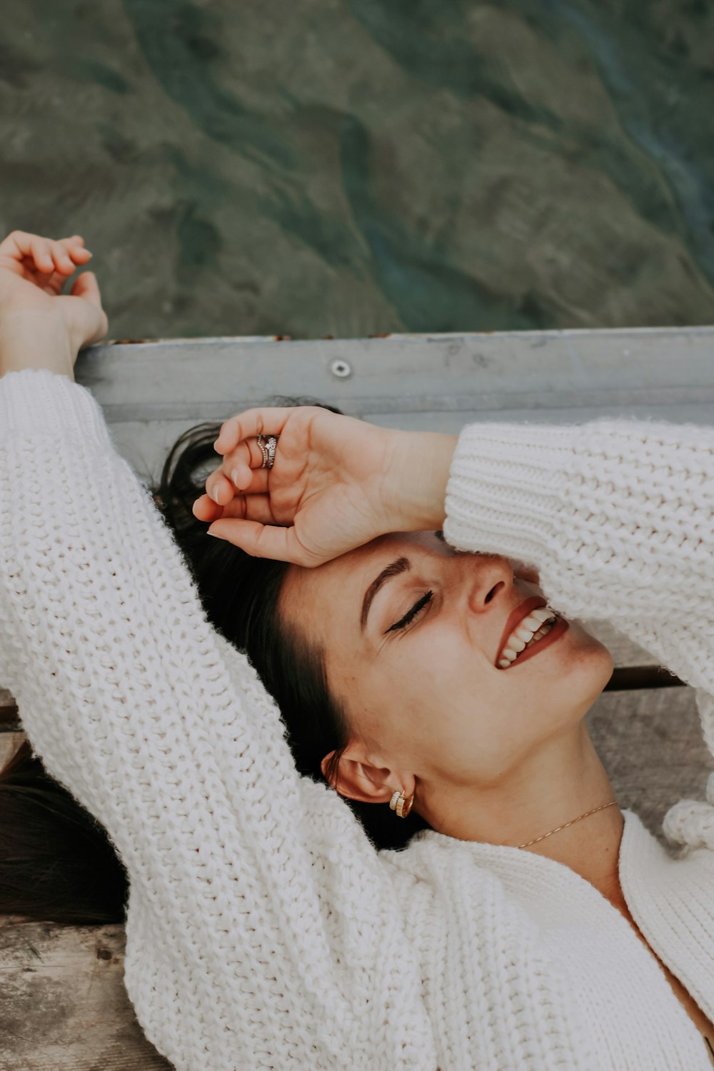 a woman laying on the ground with her hands on her head