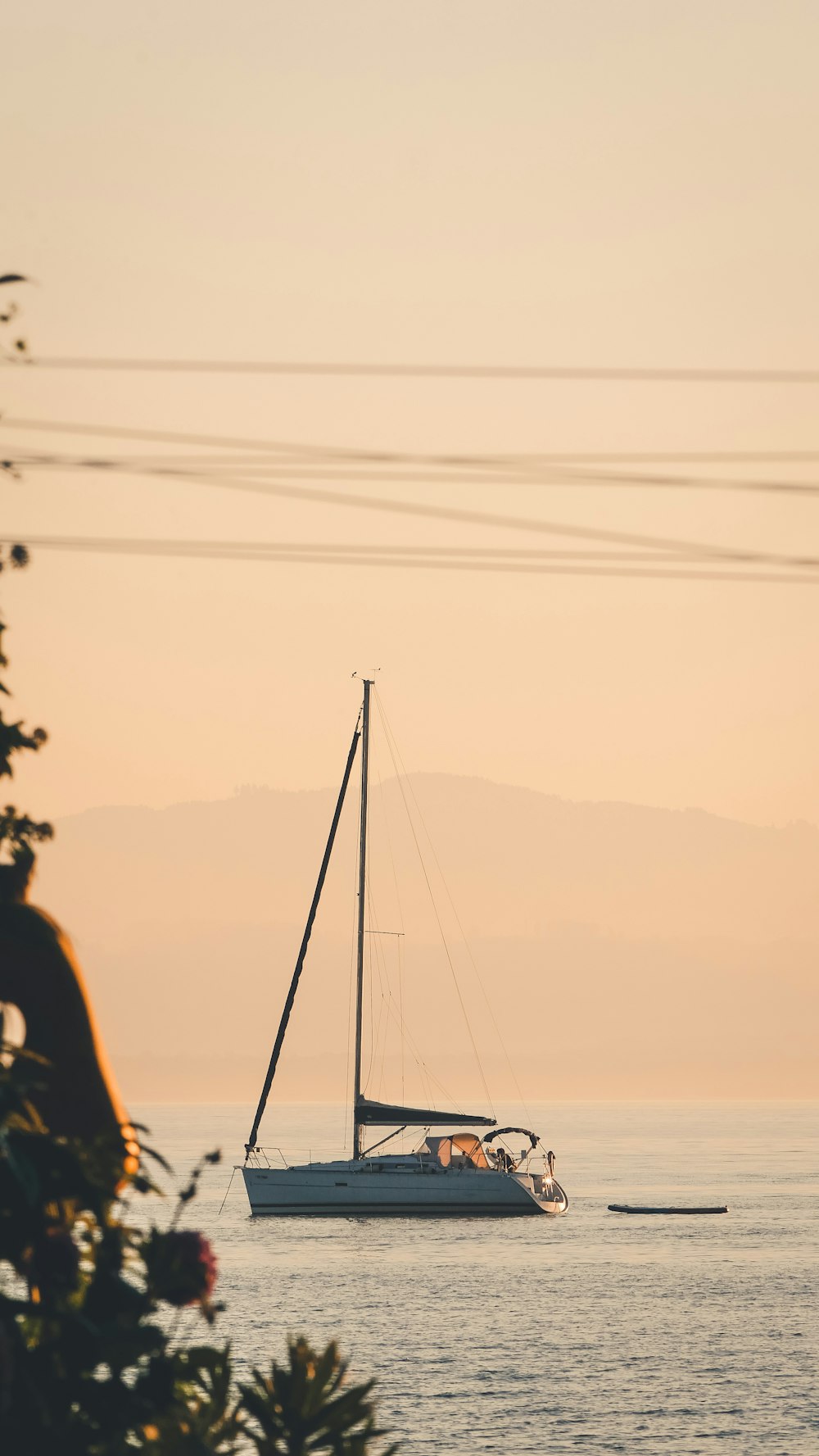 a sailboat in a body of water at sunset