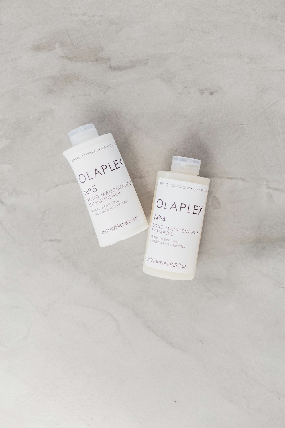 two bottles of olaplex on a marble surface