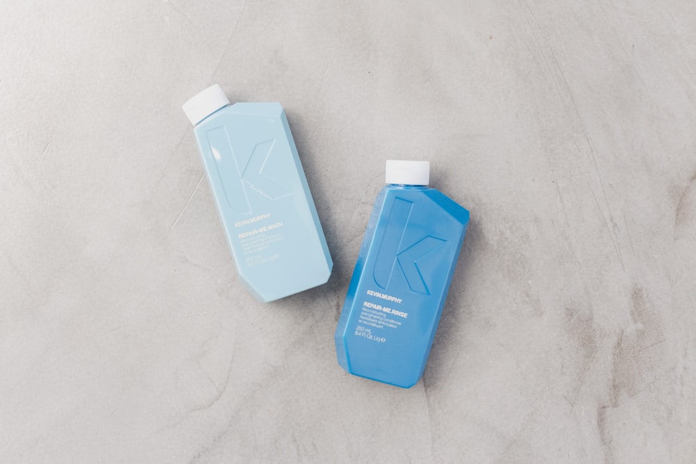 a blue bottle of shampoo next to a blue bottle of conditioner