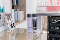 two bottles of hair products sitting on a table