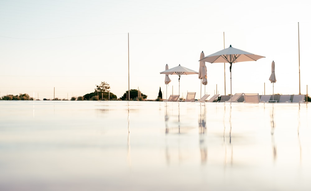 an empty swimming pool with umbrellas and chairs