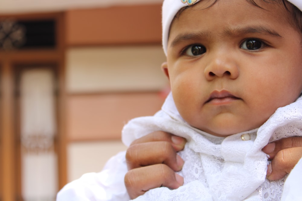 a baby wearing a white robe and a white hat