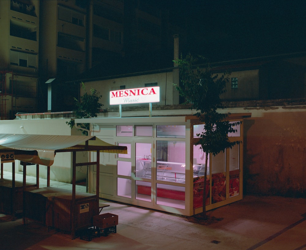 a restaurant with a lit up sign at night