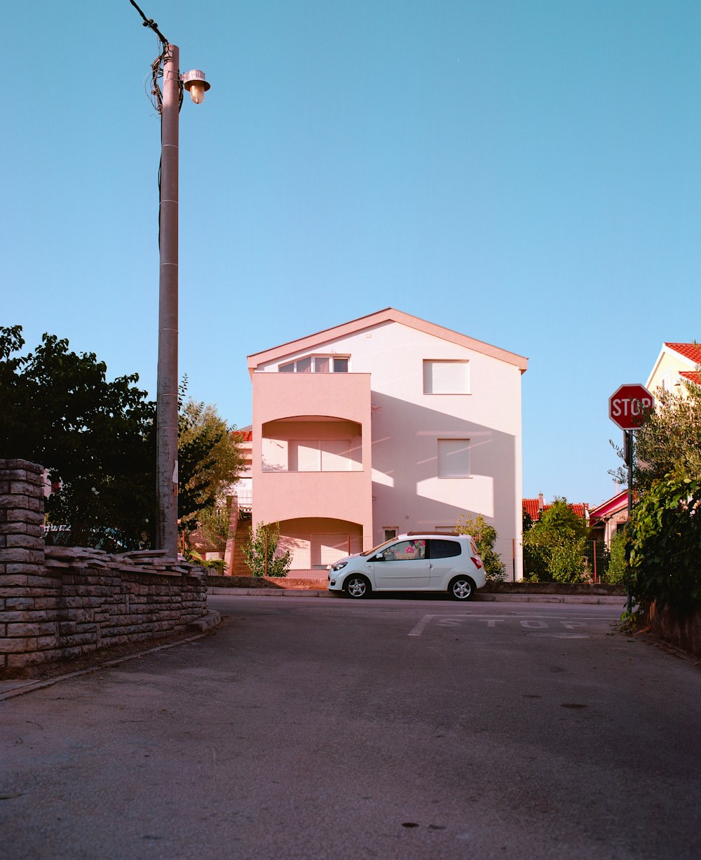 a white van parked in front of a pink building