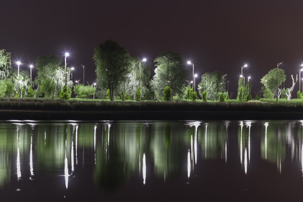 a body of water at night with street lights reflecting in the water