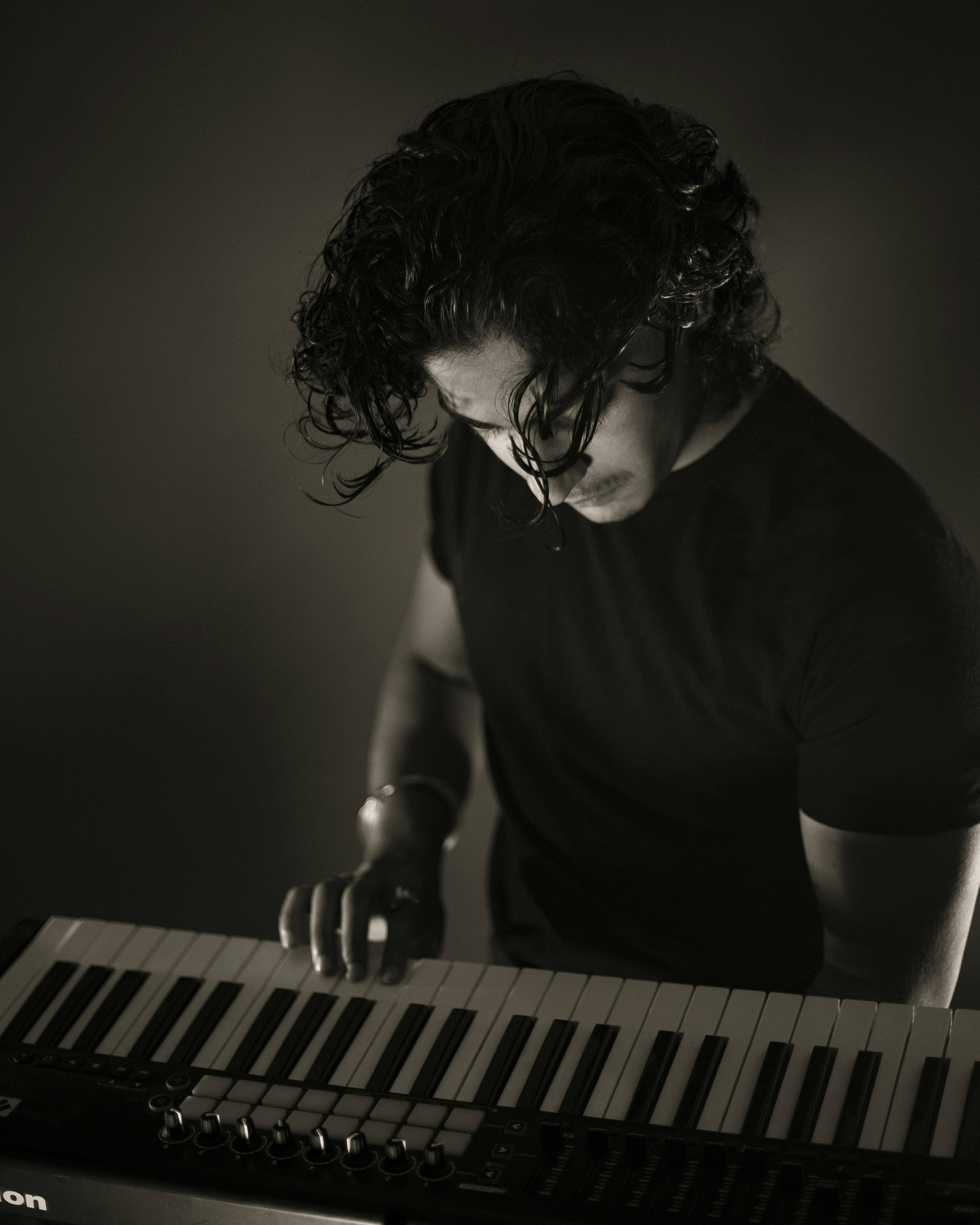 A man playing an electronic keyboard in a dark room photo – Free Human ...