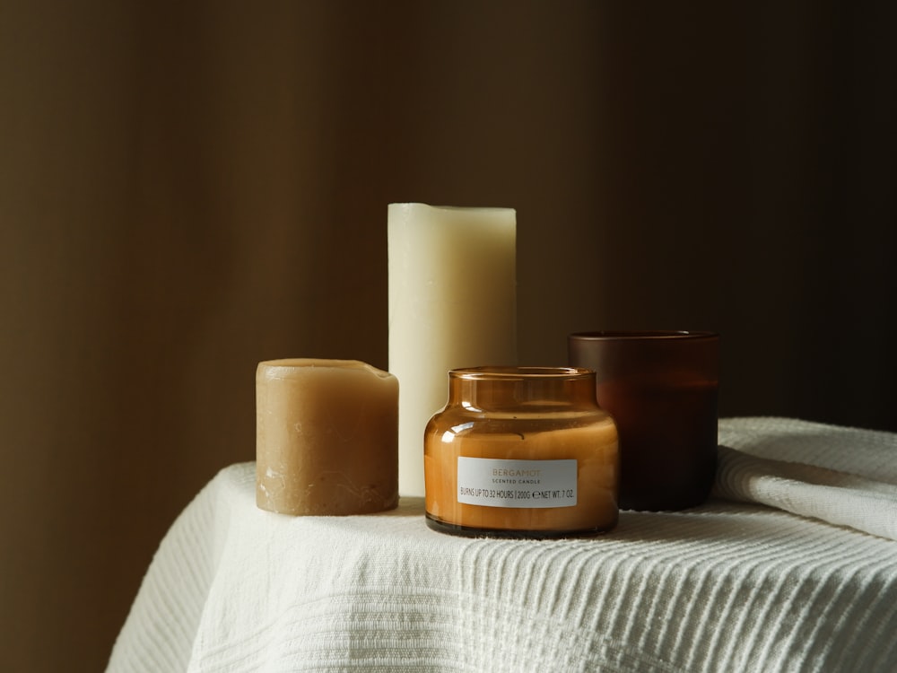 a table topped with candles and a jar of wax