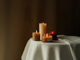 A selection of candles in different shapes and sizes on a wooden table.