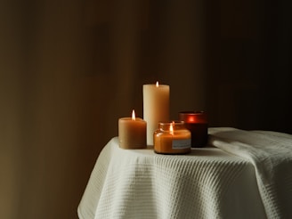 A collection of beautifully arranged beeswax candles in various shapes and sizes on a wooden table.