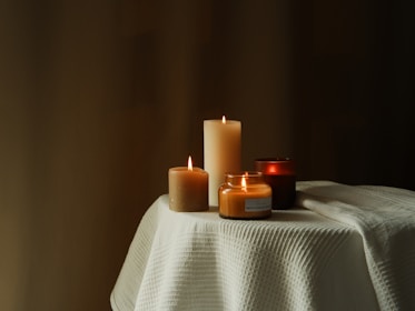An artistic shot of various candle sizes and colors.