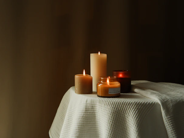 Close-up of colorful traditional wax candles arranged on a rustic wooden table.