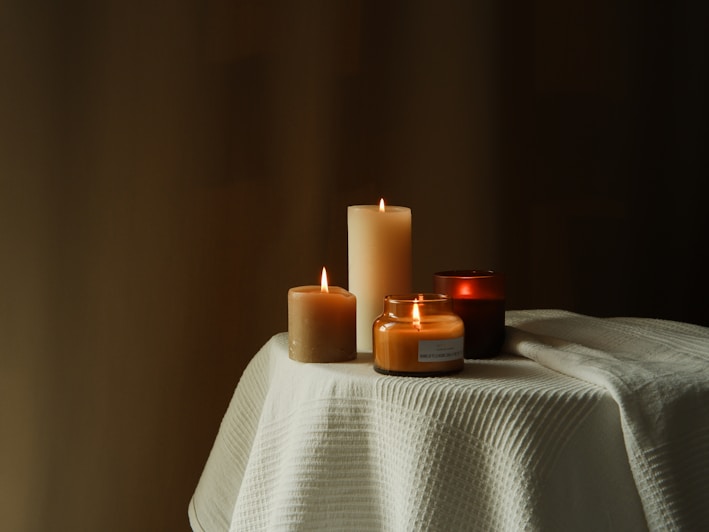 A beautifully arranged table featuring assorted handmade candles in various shapes.