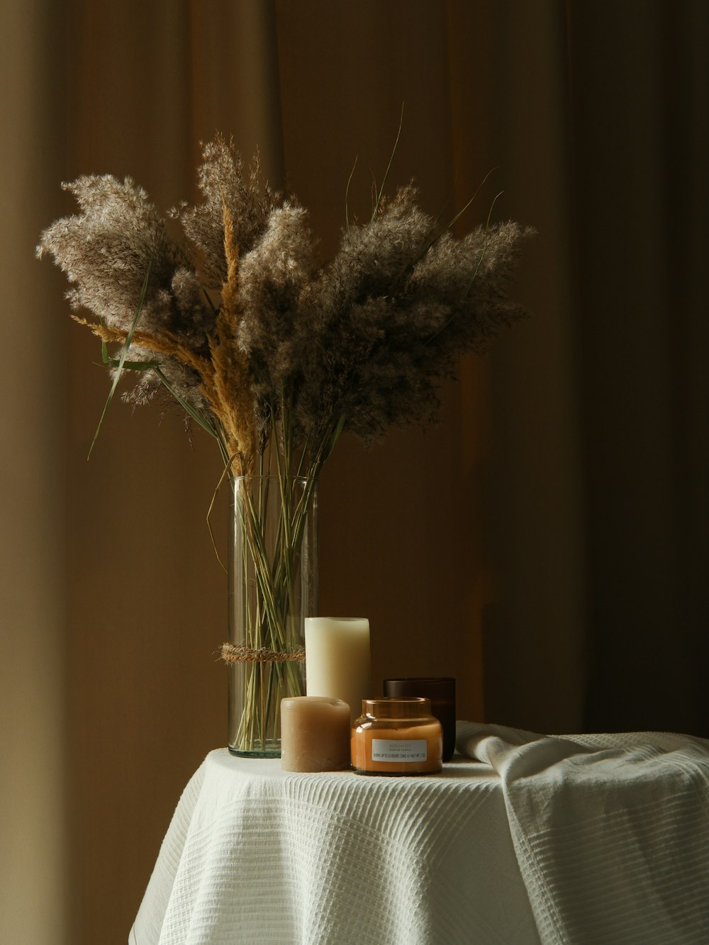 a vase with some flowers and candles on a table