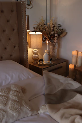 Cozy guest room featuring beige linens, charcoal headboard, and subtle gold decorative touches
