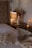 A serene bedroom with ash-candles placed on a bedside table.