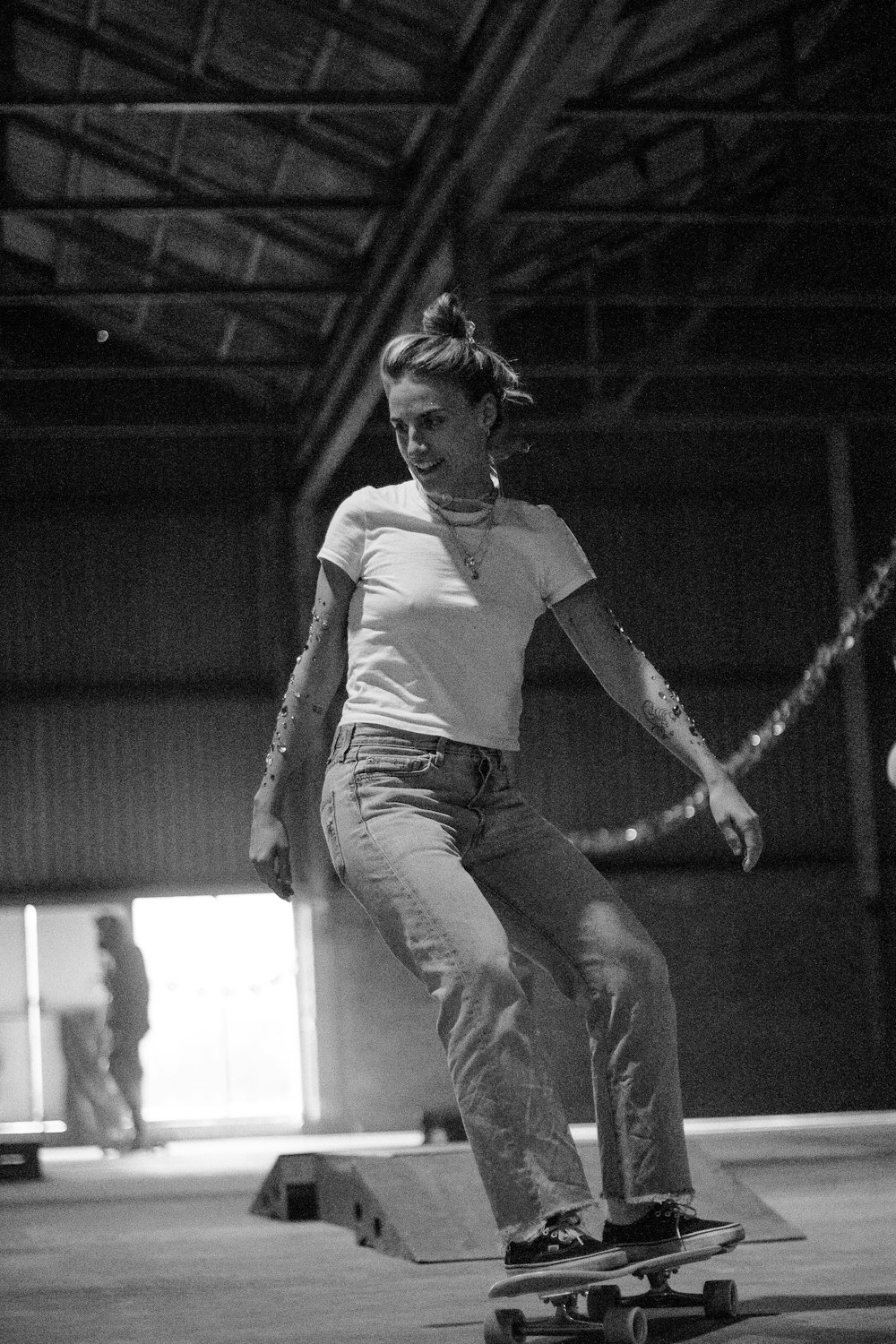 a woman riding a skateboard inside of a warehouse