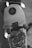 A skateboard with a graphic design featuring a stylized character. It is decorated with a string of small ghost lights, creating a playful and spooky atmosphere. The setting is dimly lit, focusing more on the skateboard and the lights.